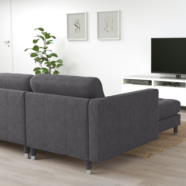 Modern grey fabric sectional sofa, large, with armrests, against white wall, near tv.