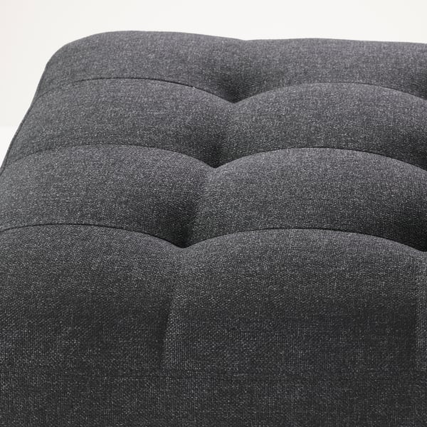 Dark grey upholstered footstool with deep tufted cushions, showing high-quality fabric and neat stitching.