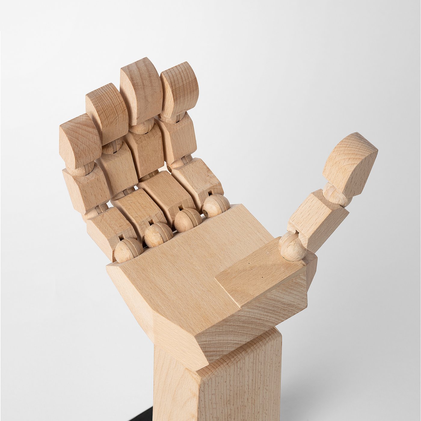 Wooden adjustable desk organiser, natural finish. Three prongs hold items, with moveable joints for customization.