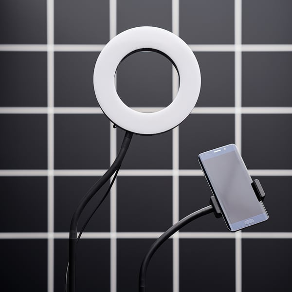 LÅNESPELARE device: white ring light, black phone holder, flexible arm, square tiled background.
