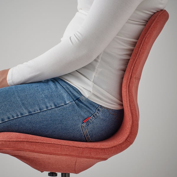 Person sitting on an orange LÅNGFJÄLL office chair, showing height-adjustable seat and lumbar support.