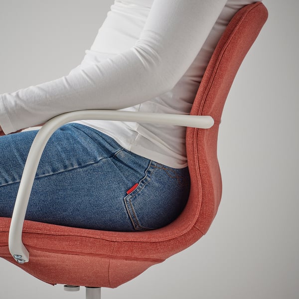 A person sits in an office chair, arm on the adjustable armrest, showing the chairs comfort and support.