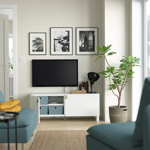Modern living room with tv on white LAPPVIKEN storage, plants, and framed pictures.