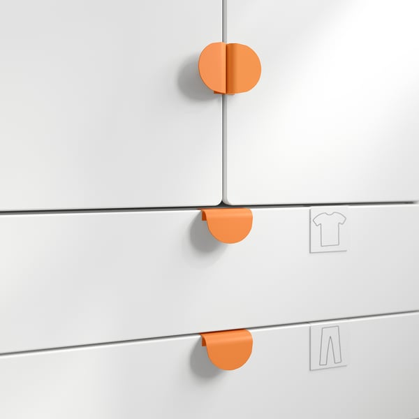 Three white cabinet drawers with rounded orange handles, aligned vertically. Top drawer slightly open. Simplistic design, easy to grip handles.