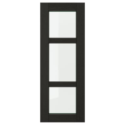 A LERHYTTAN black wooden kitchen door with bevelled edges and clear glass panels. The door has a classic, traditional design.