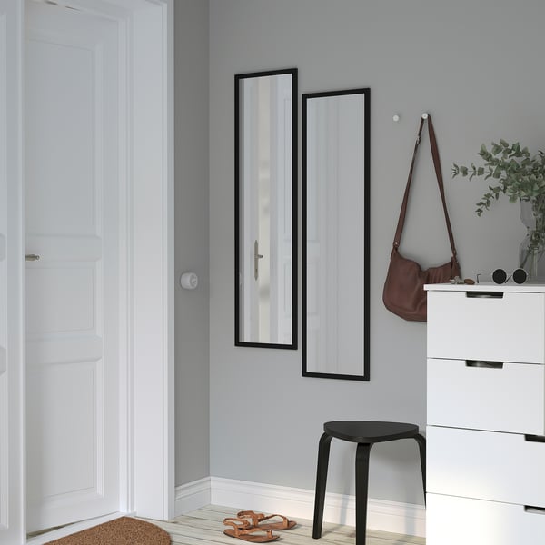 Minimalist entryway: mirror, chest, stool, bag