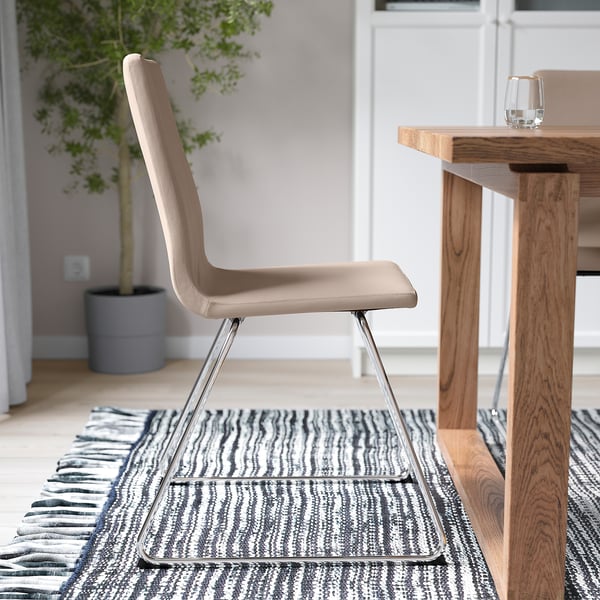Beige LILLÅNÄS chair with padded seat and chrome sled base sits near wood table on striped rug.
