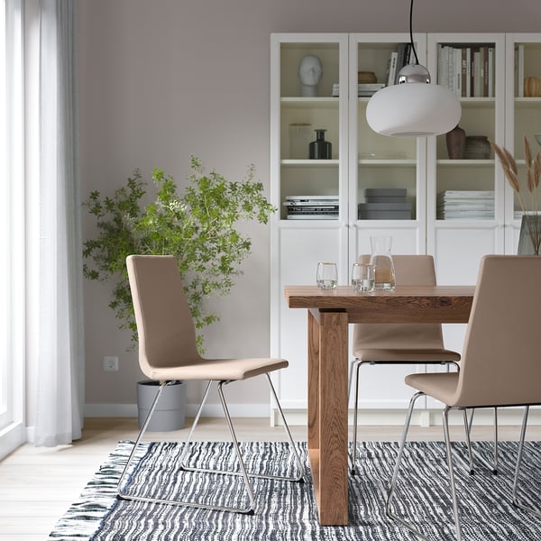 Modern dining: LILLÅNÄS chairs around wooden table, plant, black-and-white rug, pendant light.