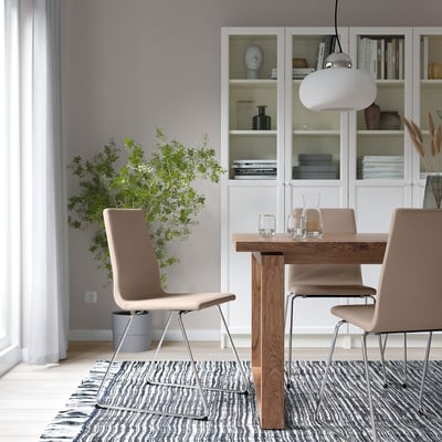 Modern dining: LILLÅNÄS chairs around wooden table, plant, black-and-white rug, pendant light.