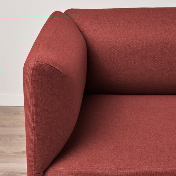 Close-up of deep red upholstered sofa, showcasing its plush cushions and sleek armrest.