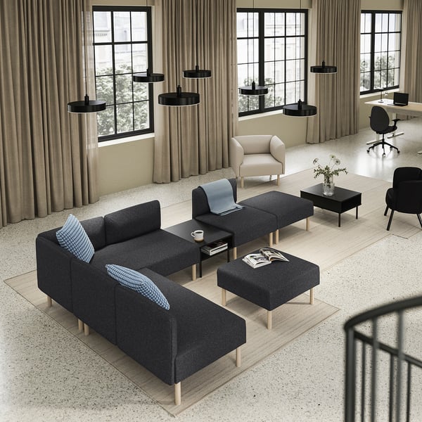 Modern living space with large windows, featuring a grey LILLEHEM sofa, black coffee table, beige armchair, and black office chair.