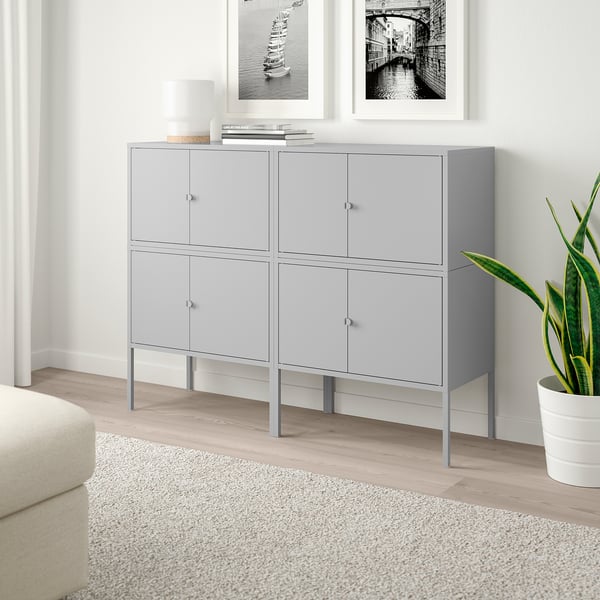 LIXHULT grey sideboard with 6 grey doors stands tall between framed photos, slightly wider than sofa, made of steel.