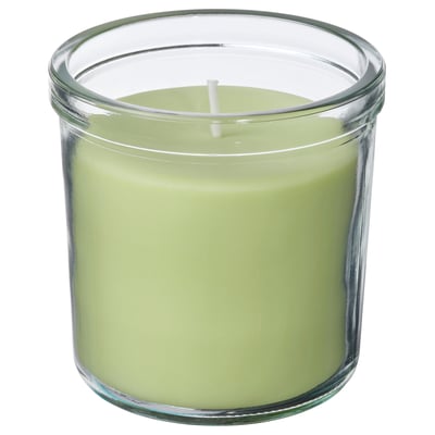 Round green scented candle in clear glass jar.