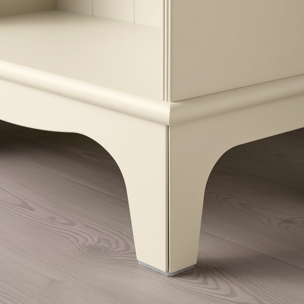 Modern cream-colored storage cabinet with curved legs on wooden floor.