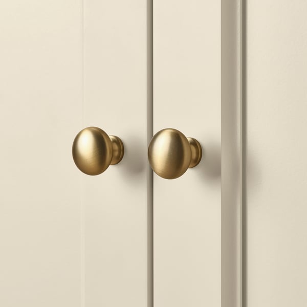 Two golden spherical knobs on a white door, indicating quality and refined design.