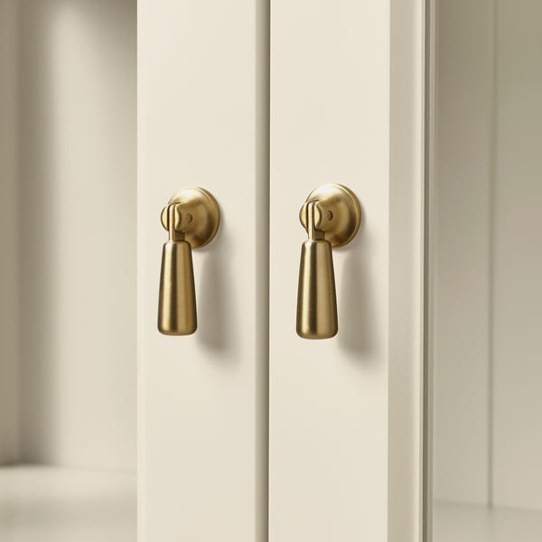 Gold cabinet handles on white doors, stylish, sturdy, modern design.