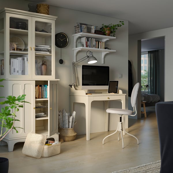 Home office with white LOMMARP cabinet, desk, chair, and shelves. Modern design, wooden and glass storage, minimalist decor.