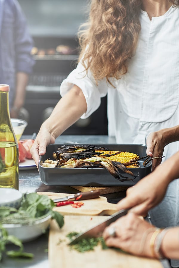 Preparing food in kitchen with LYCKAD oven dish.