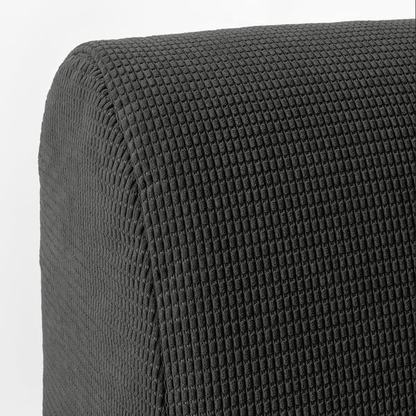 Sofa with textured, dark grey, knitted fabric cover. Soft, inviting surface, suggesting comfort and durability.