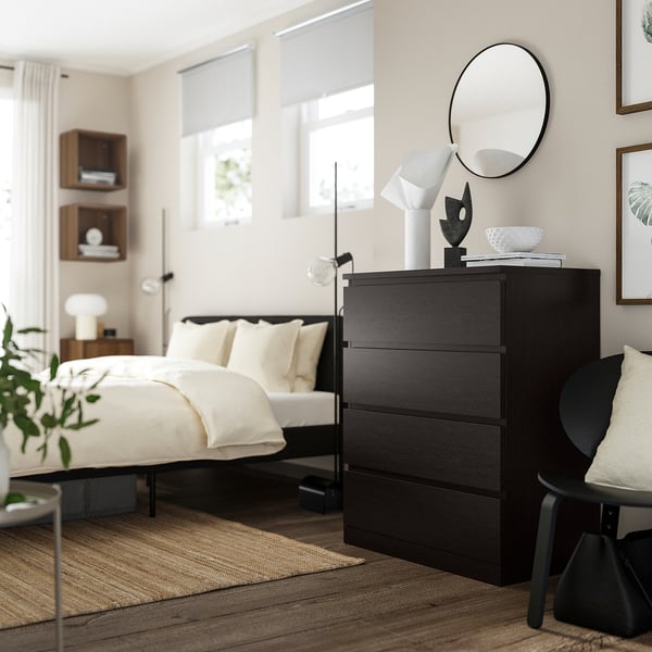 Modern bedroom with MALM black chest, mirror, vases, art, minimalist design.