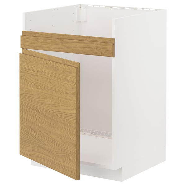 A white ikea METOD kitchen cabinet with oak wooden doors partially open, revealing an empty interior.