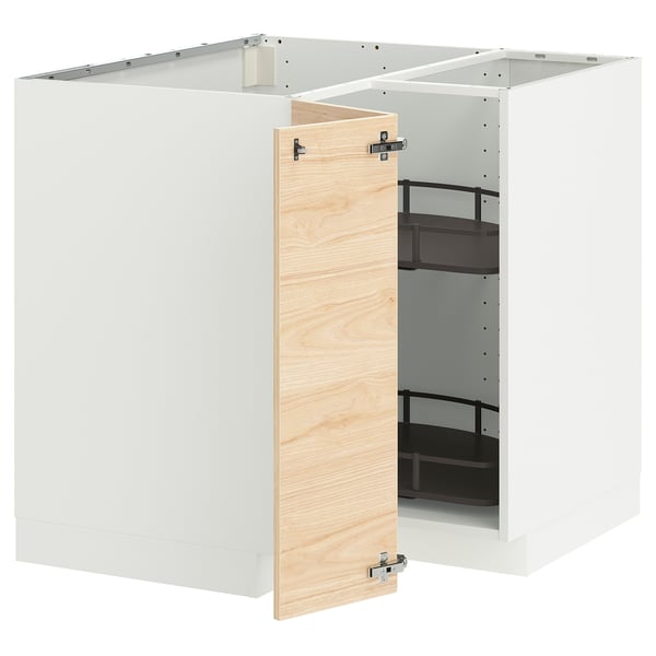 A white ikea METOD kitchen unit with an open light ash wood-patterned door, revealing adjustable black shelves inside.