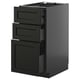 Modern black kitchen cabinet with three open drawers, sleek design, metallic handles.