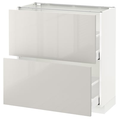 METOD high-gloss white kitchen cabinet with open drawers for storage.