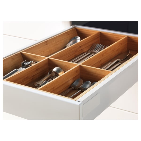 White kitchen drawer with bamboo organiser: stores spoons, forks, knives, and utensils.
