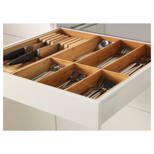 Organised kitchen drawer with bamboo dividers, holding knives and utensils.