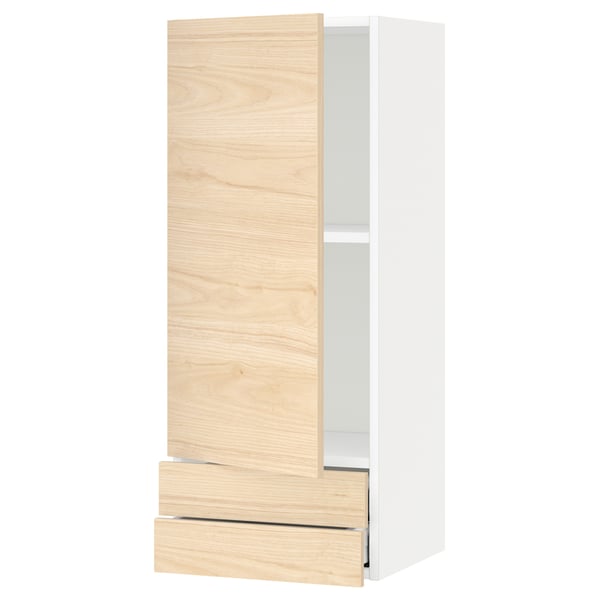 A modern light ash-colored kitchen cabinet system with a single door and drawer. It has a sleek, simplistic design and is part of the METOD series.