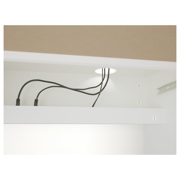 A desks back with cable outlet, black cables, and screws. Keeps cables organised and hidden.