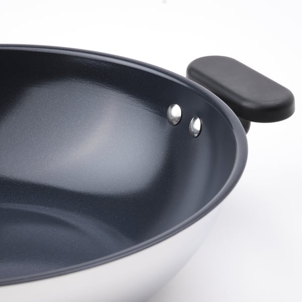 Close-up of MIDDAGSMAT woks non-stick interior and sturdy handle.