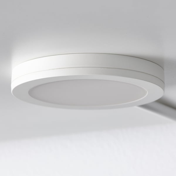 Round ceiling light embedded in white ceiling, casting soft, even light.