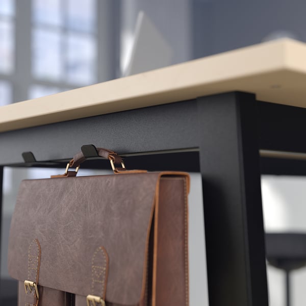 Brown leather bag hangs on black tables hook, with white shelf above and blurred background.