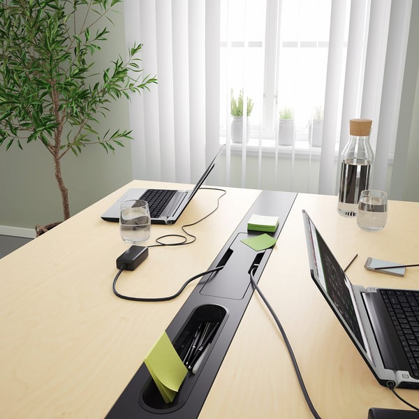 Conference table with built-in cable management, suitable for meetings or workspaces.