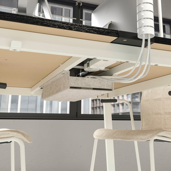 Modern office workstation with adjustable seating and overhead storage.