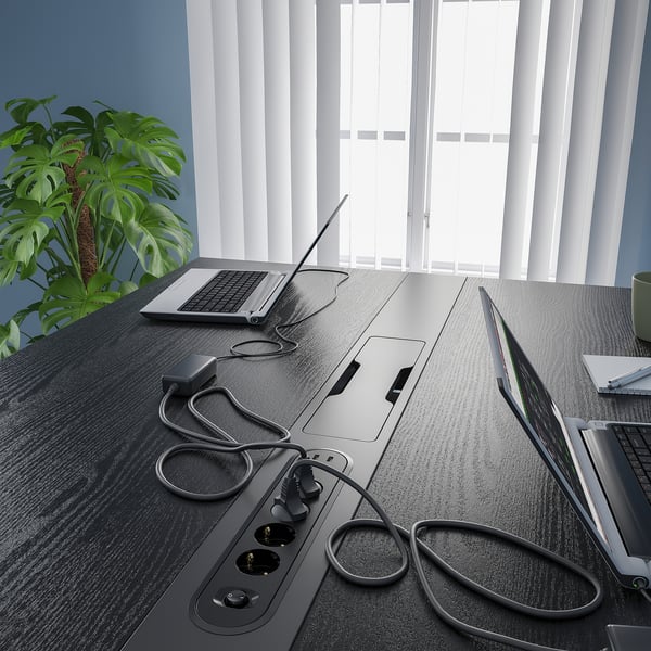 Conference table with standing/sitting options, featuring cable management and a footrest.