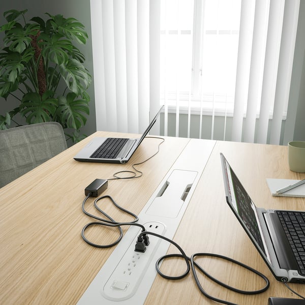 Conference table with laptops, plant. Ideal for meetings, coworking.