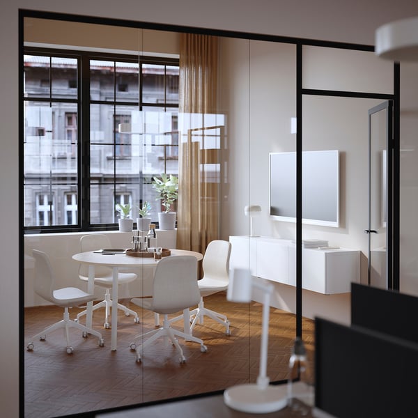 Modern office with MITTZON round table, six chairs, natural light.