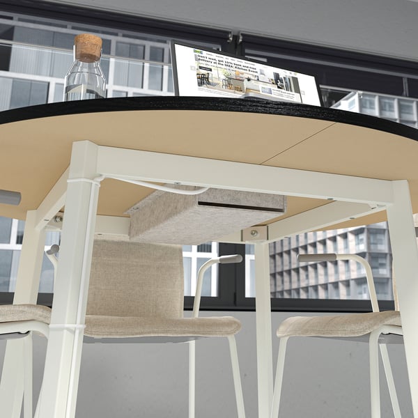 Modern office table with beige top, white legs, and integrated storage below. Cable tray visible, suitable for meetings and workspaces.
