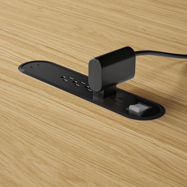 Oval power hub built into table; multiple usb ports and cable management.