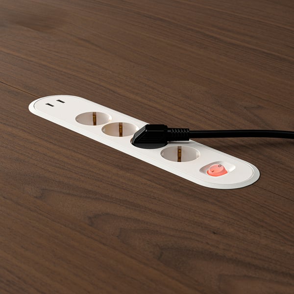 Round conference table with built-in power sockets and usb ports on wooden surface.
