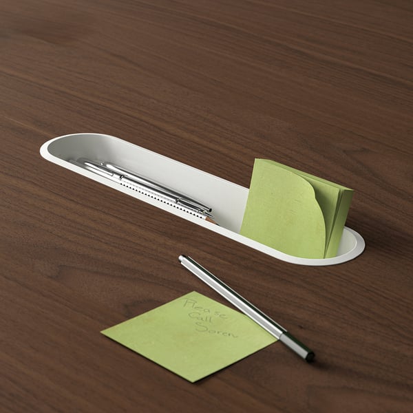 Wooden conference table with built-in storage for pens and sticky notes. Pen and note holder is visible, holding a pen and sticky notes.