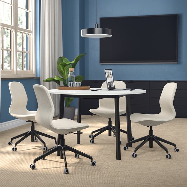 Small round conference table with 4 chairs, white, minimal storage, blue room, natural light.