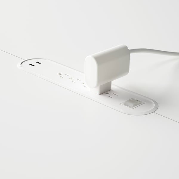 White conference table with built-in power sockets and cable management system.