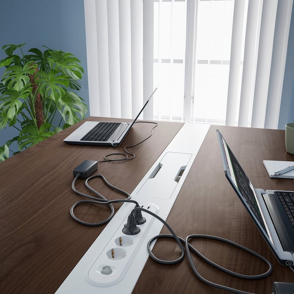 Modern office desk with power outlets and cable management, great for meetings or work.
