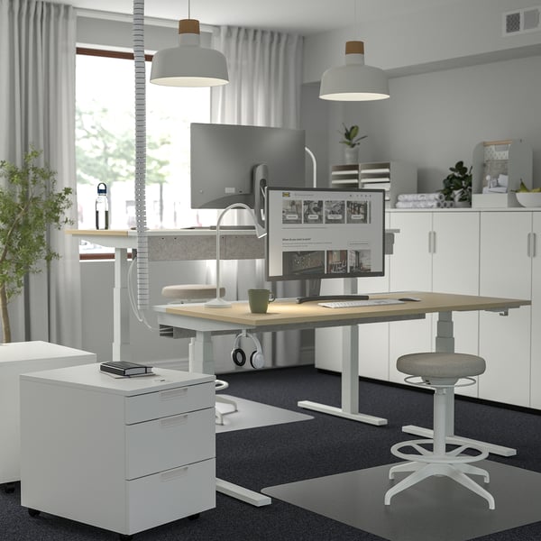 MITTZON white sit/stand desk, sleek, dual-motor. Large, modern office setup. Adjustable height, ergonomic.