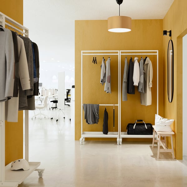 MITTZON: yellow closet with clothes, bags, helmets. Steel, rectangular, minimalist. Fits well in room, lightweight.