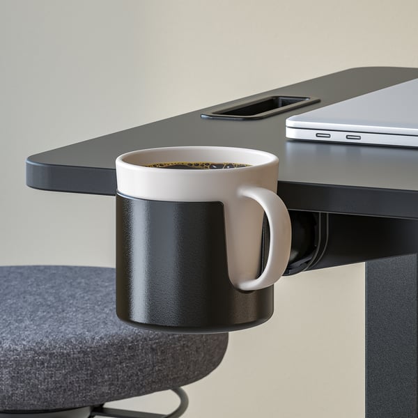 A modern office setup with a height-adjustable MITTZON table holding a laptop and a coffee mug.